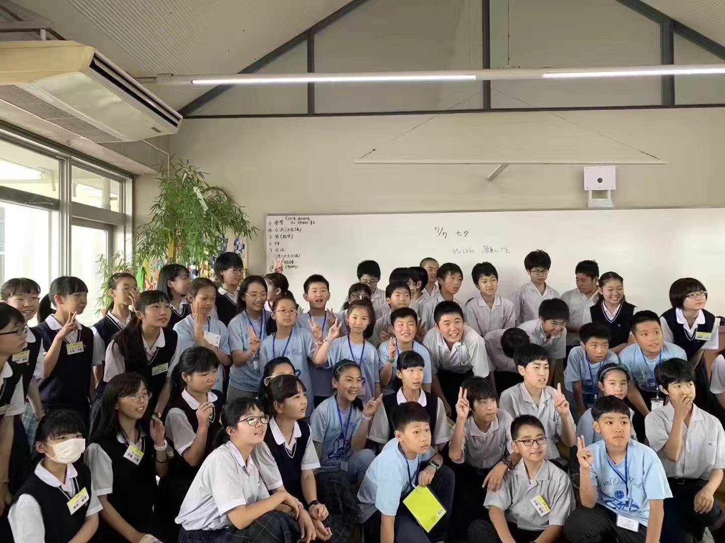 Participants gather for a group photograph in a classroom during an exchange in Japan
