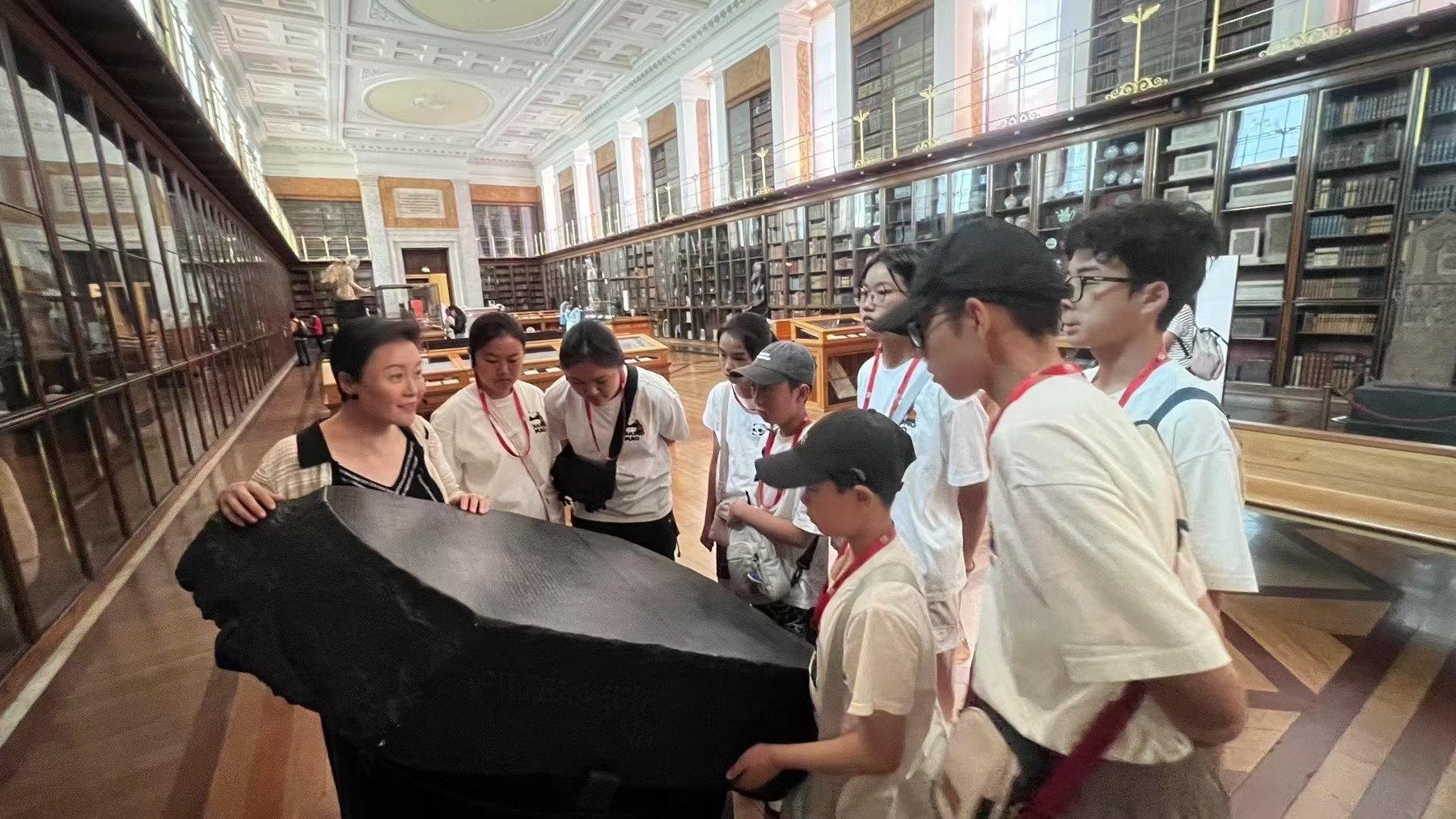 Camp participants gather around a large exhibit inside a gallery